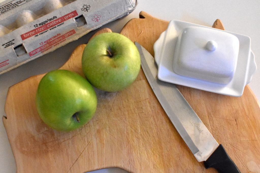 Apples, eggs, butter on cutting board