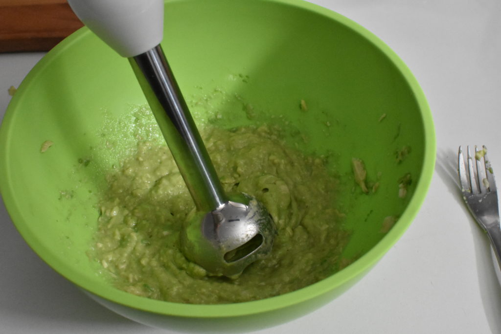Mashed avocado in green bowl