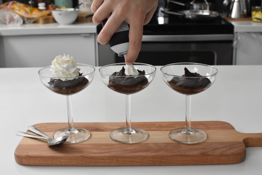 Chocolate pudding with whipped cream in cups